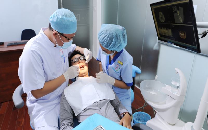 Bác sĩ tại nha khoa I-DENT đang kiểm tra răng miệng cho khách hàng